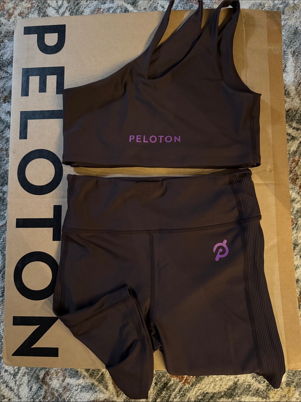 Peloton One shoulder sports bra & matching bike shorts. Brown with purple logo.